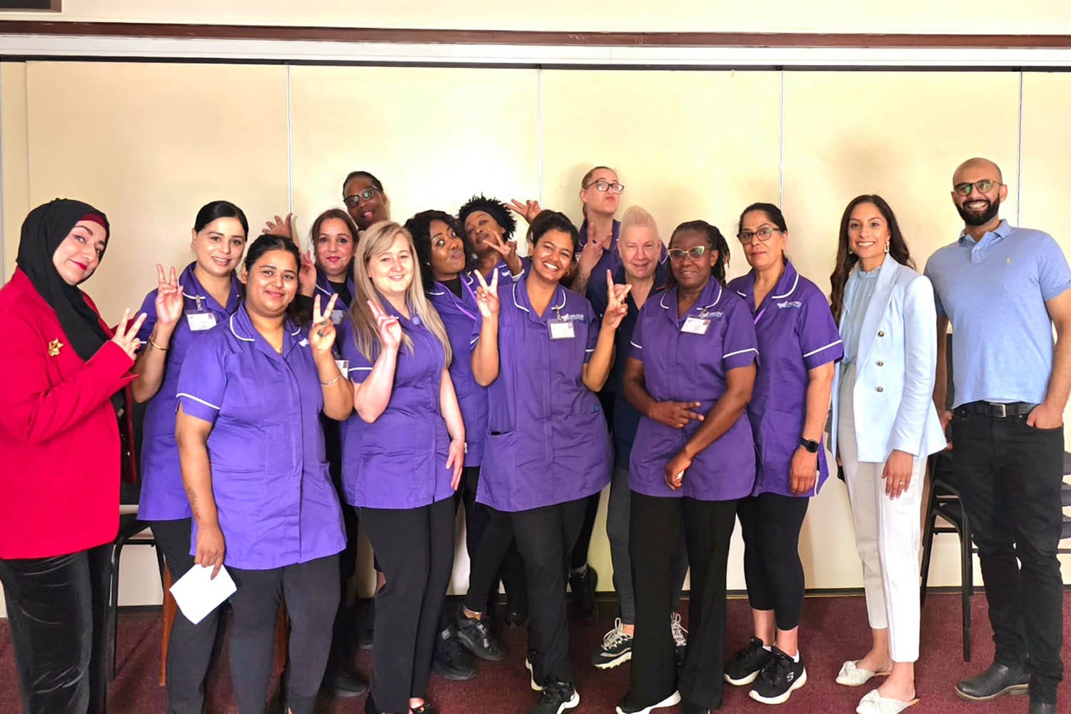 Heritage Healthcare Windsor team photo Heritage Healthcare Windsor team all smiling at the camera. The carers are wearing purple Heritage Healthcare tops and black bottoms; Prabjot is wearing a blue jacket, blue top and beige trousers; Tony is wearing a blue shirt and black trousers, and Care Manager, Sadaf, is wearing red jacket with a black top and trousers.