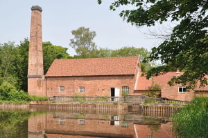 A old brick mill building next to the river with a large chimney called Sarehole Mill which is in the south of Birmingham