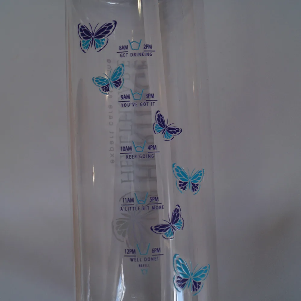 Close-up of Heritage Healthcare water bottle with time markings, detailing how much water you should have drank by a certain time. The markings start at 8 am and go down to noon before starting at the top from 2 pm till 6 pm.